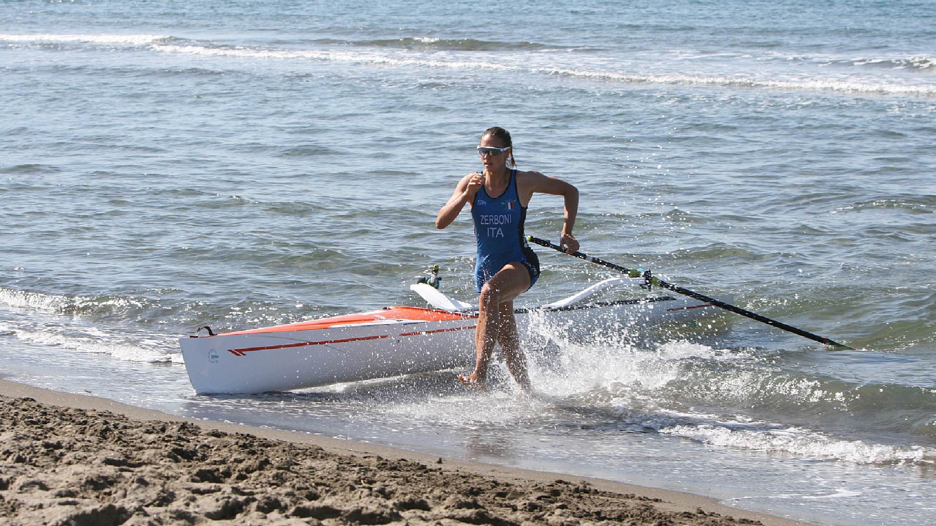 Maria Elena Zerboni jumps from the boat and runs on the sand.