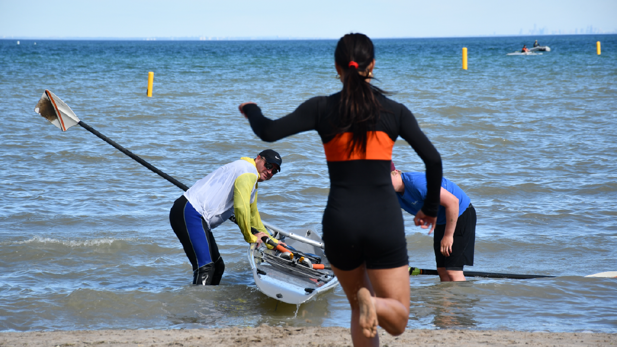 Ridley College rower runs to the boat in the RowOn beach sprint cup.