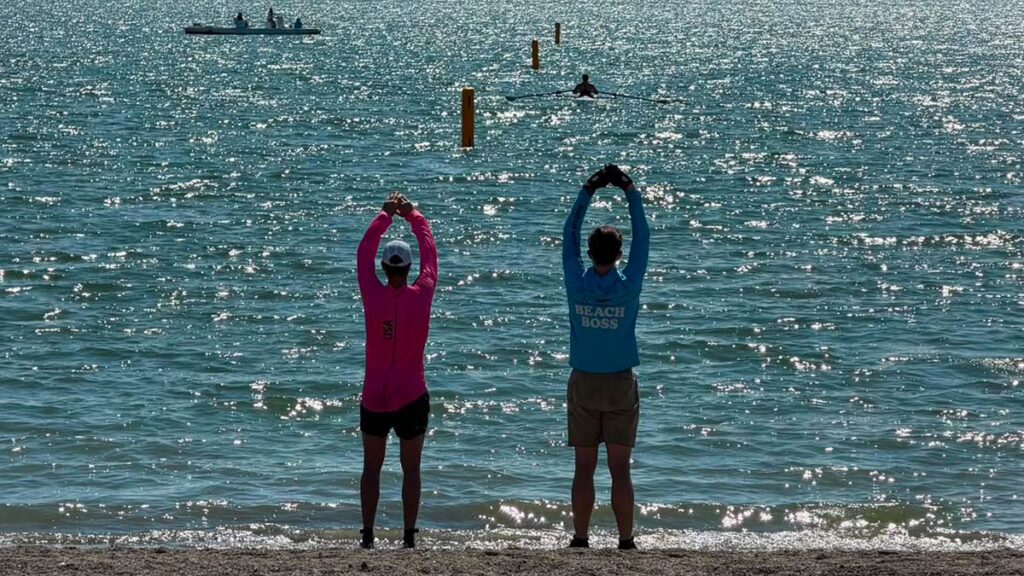 Boat handlers signal to  the water at the 2026 Boston Beach Sprints