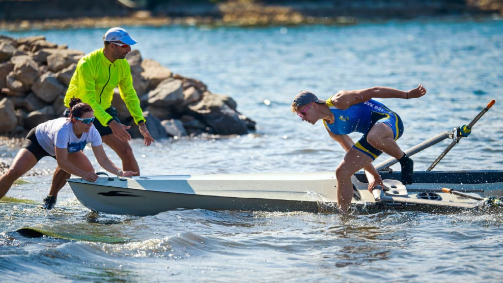Lukáš Kašík jumps from the boat and runs for the shore in the Czech Beach Sprint Cup