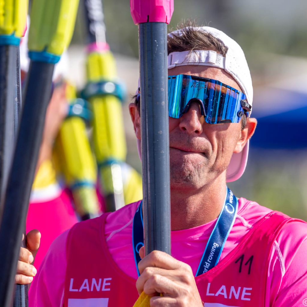 Marc Oria waits with oars for the mixed double of Chris Bak and Sera Busse at worlds in 2025.