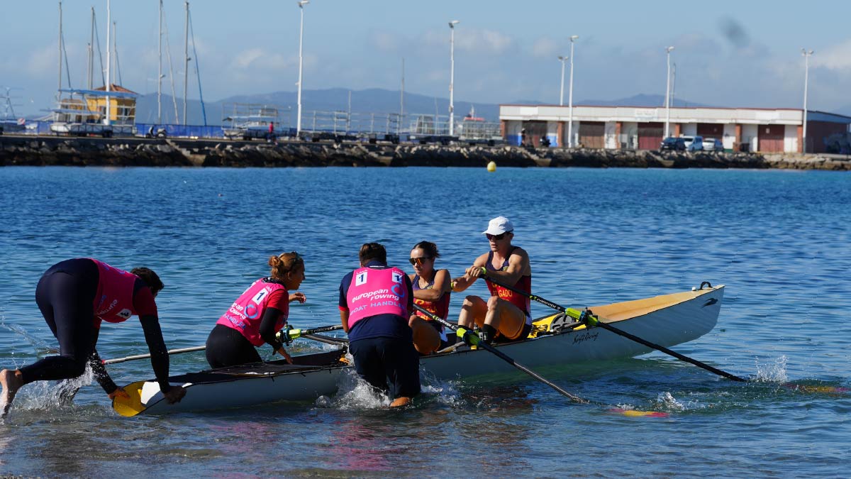 Spain's boat handlers launch Rocio Fraguela and Marcos Delgado off the beach in the inclusion mixed double.