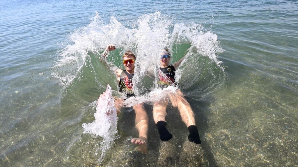 Moritz Wolff and Julia Tertuente celebrate by jumping into the water